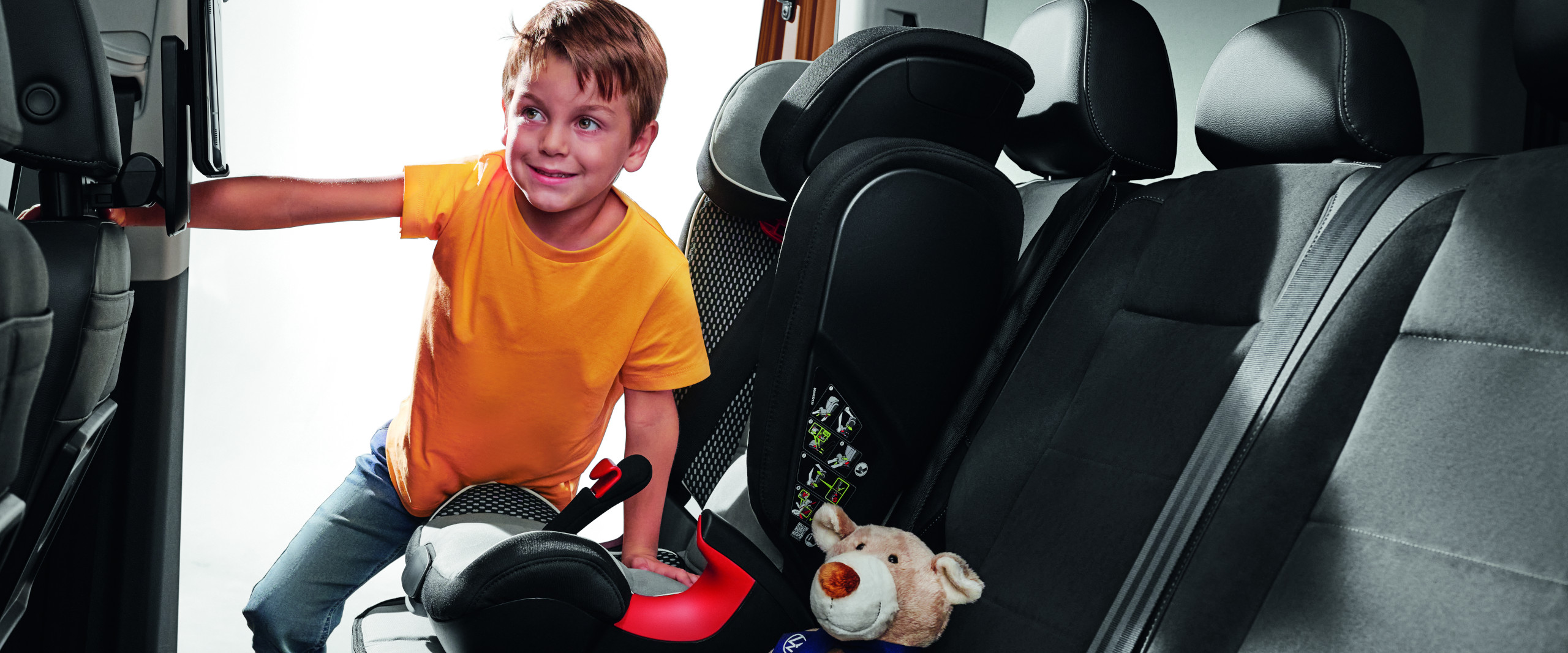 ein Kind setzt sich in den VW Kindersitz