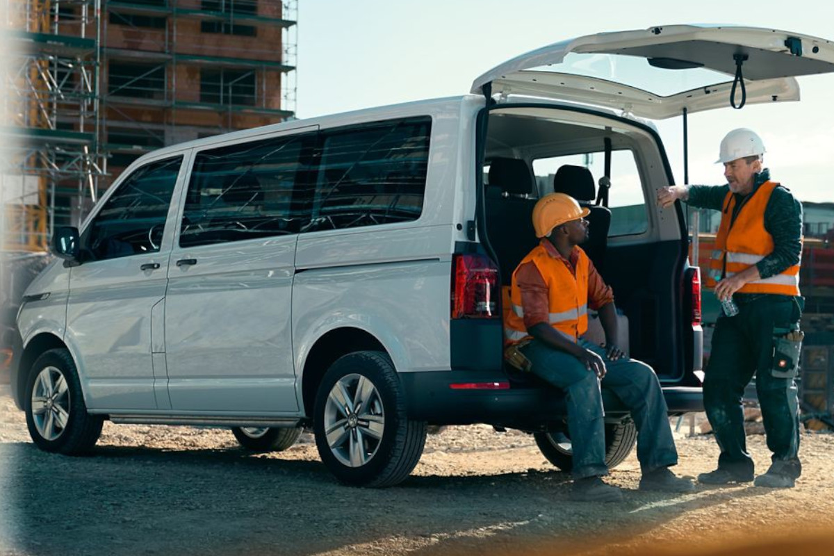 zwei Bauarbeiter unterhalten sich am VW Transporter Kombi